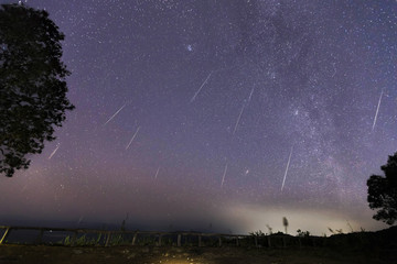 Obraz premium Geminid Meteor Shower and the Milky Way Over a mountain. Geminid Meteor in the night sky