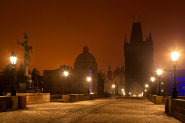 Fototapeta premium Night Prague. Beautiful cityscape with silhouettes of watchtowers on the Charles Bridge in the winter twilight