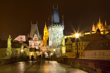 Fototapeta na wymiar Evening in Prague. Beautiful cityscape with the Bridge Towers of Charles Bridge and the spiers of St. Vitus Cathedral during the winter holidays