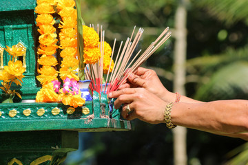 Asian people with incense pay respect to shrine or spirit worship.