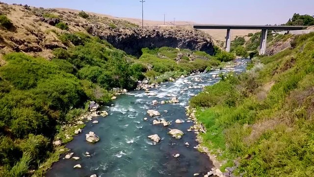 Aerial of a river coming up on a bridge. 