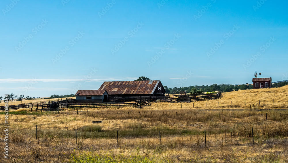 Wall mural Rural life in California. Old ranch among the fields