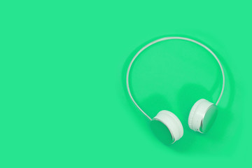 Wireless headphones isolated on light green background. bluetooth