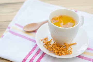 Dried Cordyceps Militaris Mushroom with Cup on white cotton fabric background