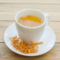 .Dried Cordyceps Militaris Mushroom with Cup on wooden table background