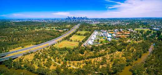 Fototapeta na wymiar Aerial panorama of Eastern Freeway and Melbourne CBD skyscrapers on bright summer day