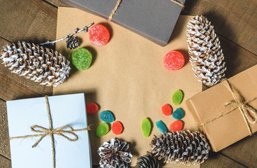 Boxes with gifts, cones, candies and marmalades, free space  on a wooden background