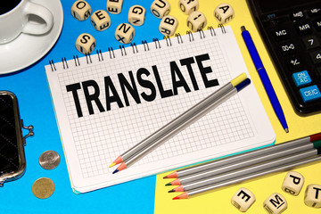 Notebook with Notes TRANSLATE with office tools and dice with letters . Concept TRANSLATE