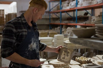 Male potter examining a clay