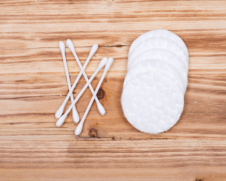 Organic double end cotton ear and make up swabs, buds and make up remover pads on wooden vintage background