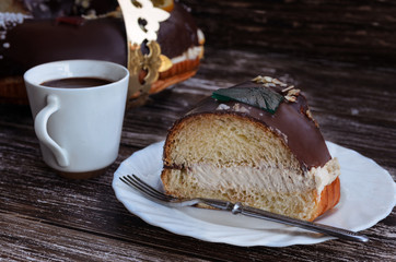 Roscon de reyes, spanish desert to celebrate Epiphany or Dia de Reyes Magos , Three Wise Men Day. Spanish Christmas cake with cup of hot chocolate on wooden background.