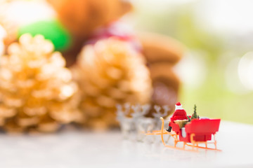 Miniature Santa Claus drive a wagon with a reindeer during the snowfall. Using as concept in Christmas day.