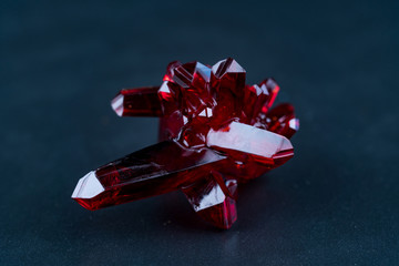 red crystal of natural origin. close up of crystals in ruby color on black background