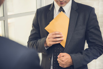 Businessman putting the envelope into his suit pocket