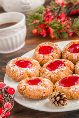 Christmas decoration and sweet cookies with red berry jam on a white plate on the wooden table