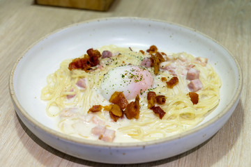 Spaghetti Carbonara white sauce topped ham and bacon with egg boiled