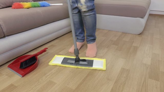 Woman's legs and mop moving in music rhythm