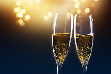 toasting with champagne glasses against holiday lights and new year fireworks