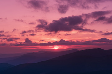 Amazing mountain landscape with colorful vivid sunset on the bright sky, natural outdoor travel background