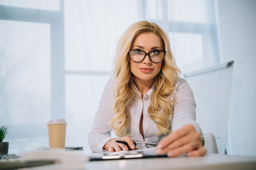 beautiful businesswoman sitting at table with documents