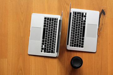zwei Notebooks mit Kaffeebecher
