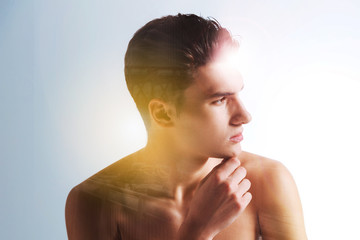 Deep thoughts. Pleasant nice young man turning his head and holding his chin while having deep...