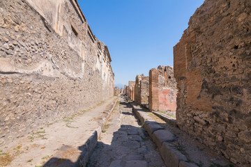 Walking around the ruins and the empty streets of the ancient antique site of Pompeii destroyed by...