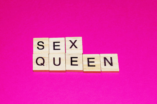 Wooden blocks on a pink background spelling words Sex Queen