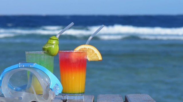 Cinemagraph - Swimming mask and two alcoholic cocktail on the background of the sea.Tropical vacation on beach. Motion Photo.