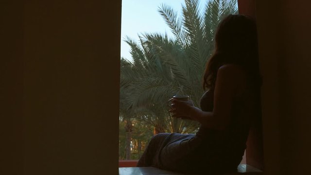 Cinemagraph - Young woman drinking a cap of tea on the balkony in the morning .  Motion Photo.