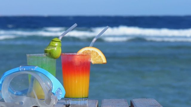 Cinemagraph - Swimming mask and two alcoholic cocktail on the background of the sea.Tropical vacation on beach. Motion Photo.