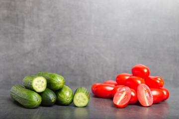 mini cucumber and tomatoes on a grey background