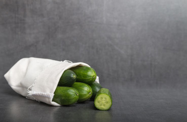 mini cucumber in a bag on a grey background