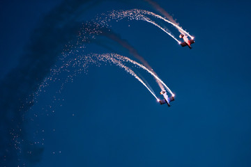 Two planes on the sky during the night airshow. - obrazy, fototapety, plakaty