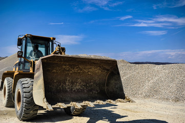Gravel excavation site in a sunny day industrial machines.