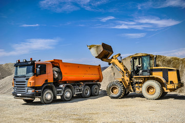 Gravel excavation site in a sunny day industrial machines.
