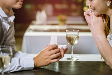Man open a ring box to give a gift to his girlfriend.