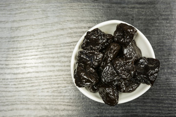 A bowl with dried plums. View from above