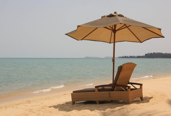 Sun lounger with a parasol against the sky and the sea.
