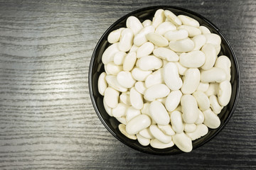 A bowl with peas on the table. View from above.