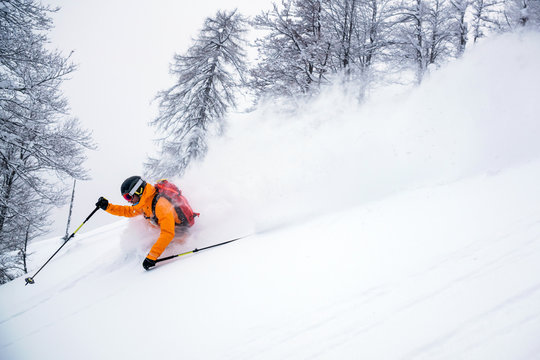 A male skier is riding in fresh powder snow at the Gosau valley in Austria.