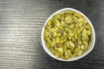 White bowl with pumpkin seeds. View from above.