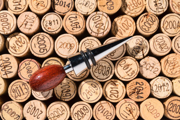 Eleganter Flaschenverschluss aus Holz und Metall liegt auf einem Hintergrund aus vielen...