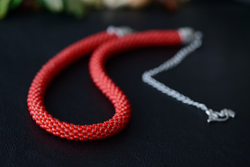 Red bead crochet necklace a dark background close up