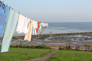 Wäscheleine mit Wäschestücken in Richtung Wattenmeer auf einer Warft .Where: Hallig Langeneß.When: 25.9.2011.