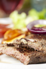 Gegrilltes Steak mit roten Zwiebeln auf einem Teller