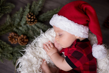 Fototapeta na wymiar Little baby boy with christmas clothes, sleeping in basket