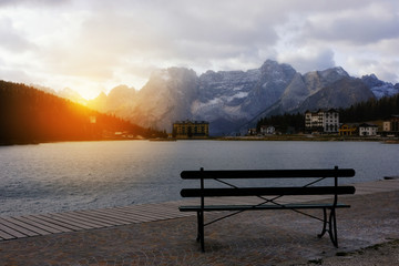 Fototapeta na wymiar Bench with scenic alpine mountain lake view