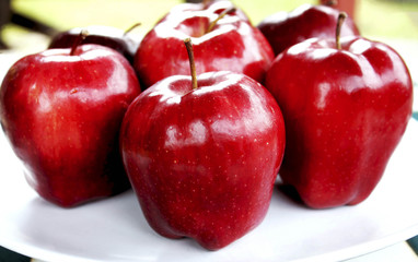 Red apples on white dish