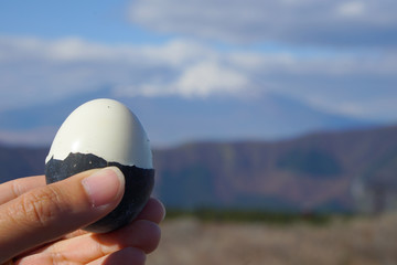 Man hand shows black eggs owakudani  on the volcano Fuji.
